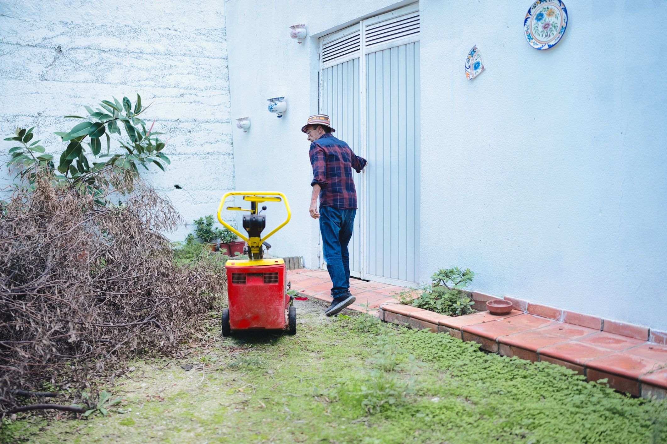 Worker operating a wood chipper during yard cleanup