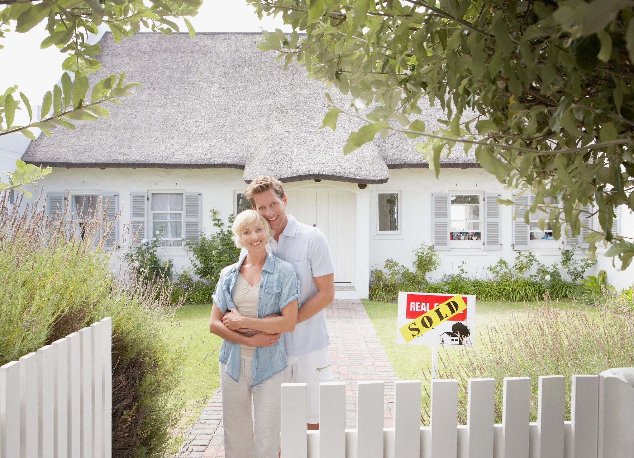 Homeowner couple standing outside their house